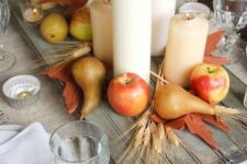 a harvest fall centerpiece of a wooden board, wheat, apples, pears, leaves and pillar candles is amazing
