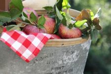 a metal bathtub with a plaid napkin, foliage, apples and twigs can be a nice outdoor-indoor decoration
