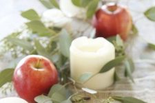 a natural fall garland of eucalyptus, apples and pillar candles is a gorgeous fall decoration to rock