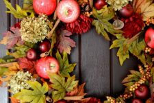 a rustic fall wreath of faux leaves, berries, apples, blooms and cinnamn sticks is lush and amazing