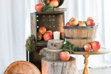 pretty woodland and rustic decor with apples in wooden baskets, moss, tree slices and stumps, candles on the floor