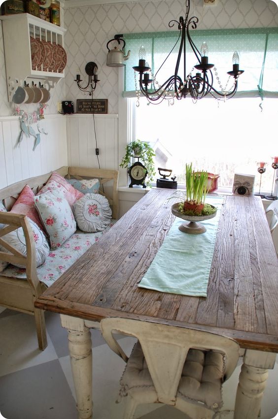 reclaimed wood table with a delicate table runner and a shabby bench with floral textiles