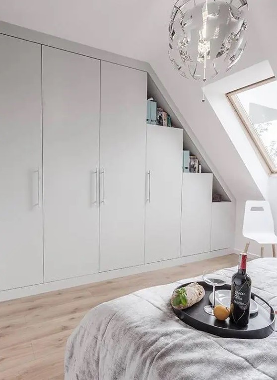 a Scandinavian bedroom with a skylight, a built-in storage unit with open shelves, a bed with neutral bedding