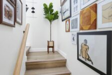 a beautiful gallery wall that takes two walls over the staircase and includes various works of art and graphic art is a cool idea
