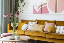 a bold and catchy living room with a mustard sofa, a mauve pouf, a coffee table, a ledge with artwork and green curtains