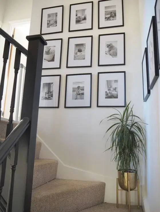 a chic grid gallery wall with matching black frames and black and white photos is a lovely way to display your family pics