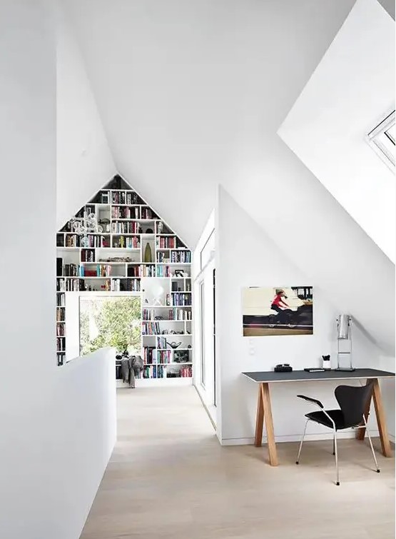 a clean Scandinavian airy home office with a simple lightweight desk, a black chair, a large bookshelf taking the whole wall and a windowsill daybed