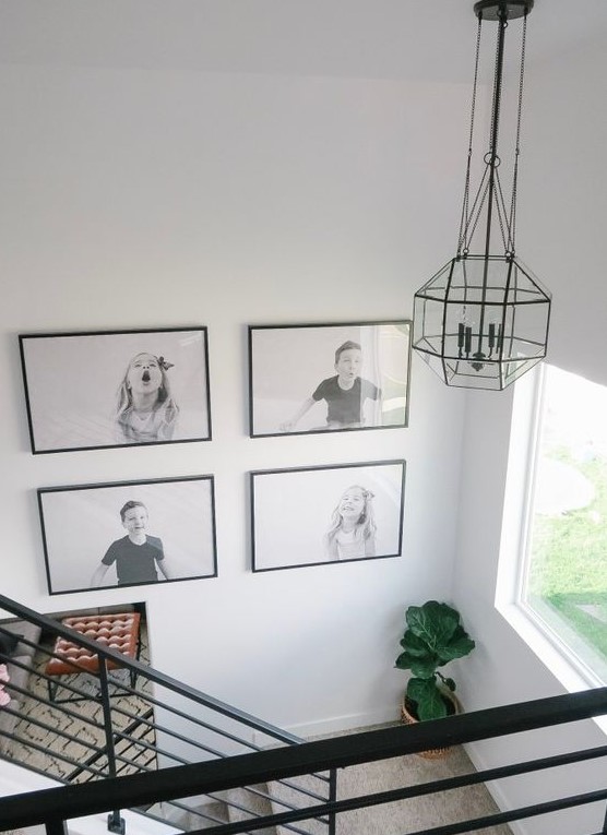a cool black and white grid gallery wall with black frames shows off kids' pics and adds fun and coziness to the space