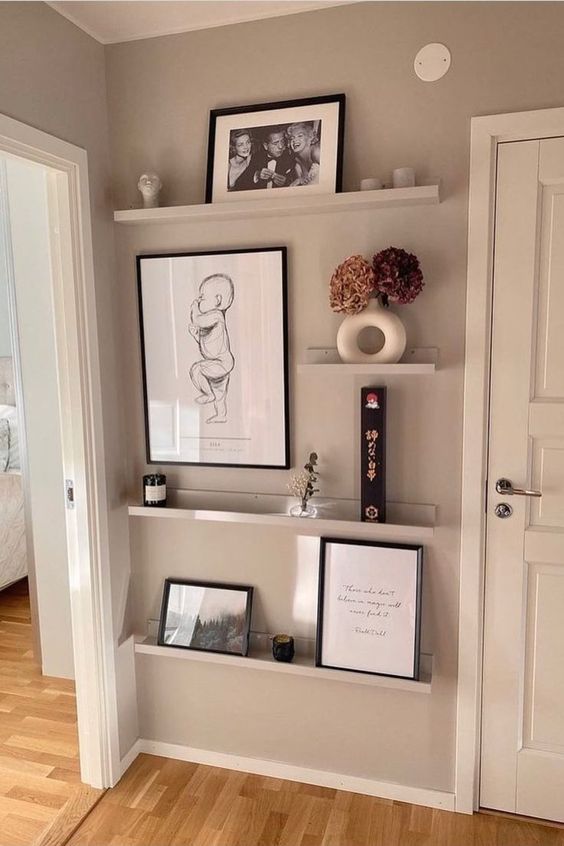 a cool gallery wall with ledges and artwork, photos, dried blooms and some decor is a cool decor idea for your home