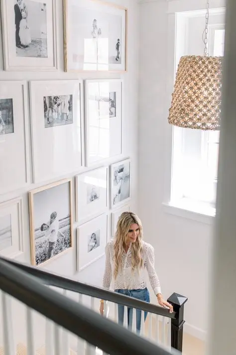 a floor to ceiling gallery wall over the staircase is a cool idea for your space, it looks chic and relaxed, and light frames make it cool lightweight