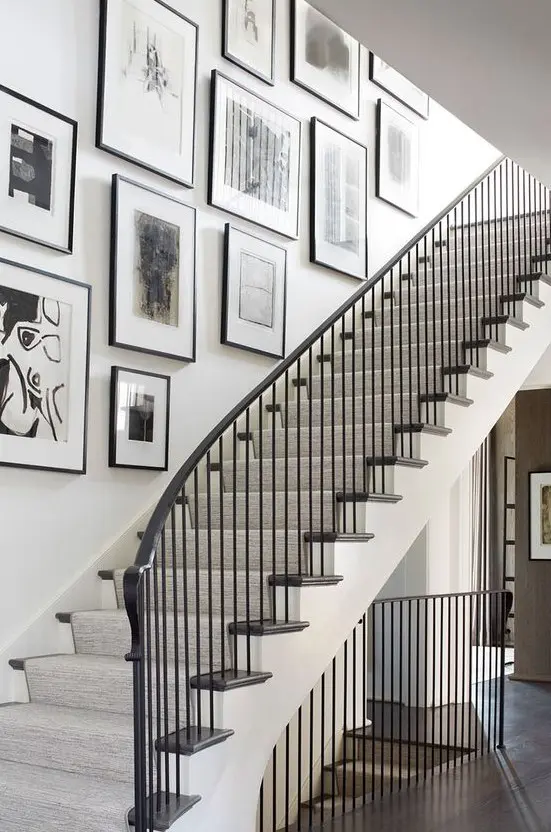 a free form gallery wall with black frames and black and white artworks adds elegance and chic to the space and makes it artful