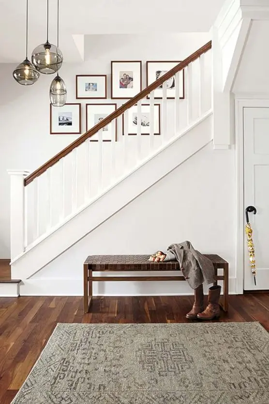 a free form gallery wall with colored family photos is a fresh and cool idea to spruce up the space over the stairs