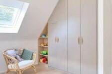 a kids’ playroom with a built-in attic storage unit with wardrobes and open shelves is a very smart solution that saves space