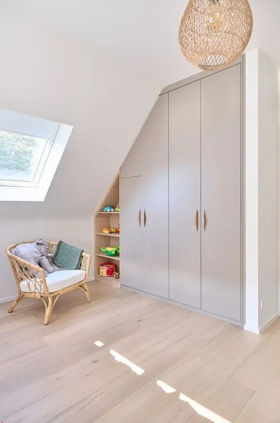 a kids' playroom with a built-in attic storage unit with wardrobes and open shelves is a very smart solution that saves space