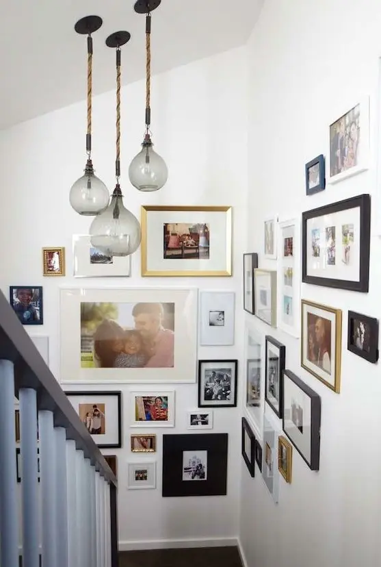 a large family gallery wall with mismatching frames and various black and white and colored artworks is a cool idea