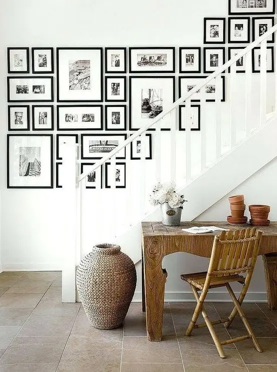 a large free form gallery wall with black frames and black and white prints is a stylish idea with an eclectic yet elegant feel