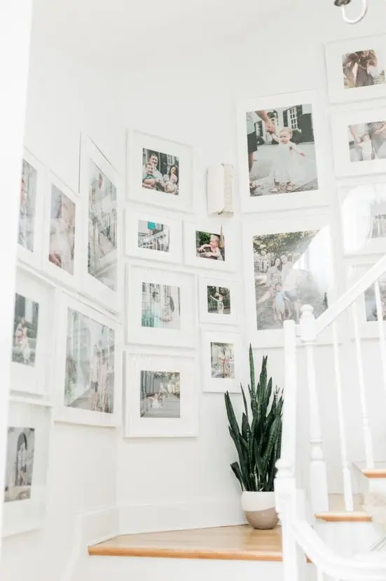 a large gallery wall done with IKEA Ribba frames and colorful family photos with matting is amazing and very fresh