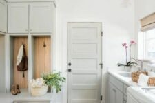 a ligth grey farmhouse mudroom laundry with open racks and cabinets, a tiled floor and some greenery and blooms