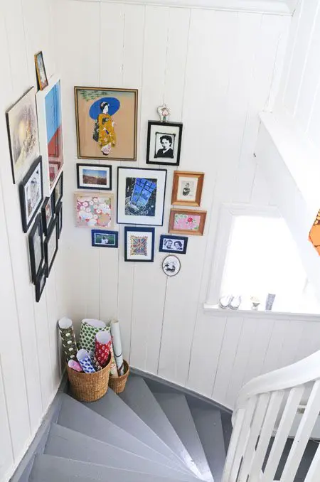 a lovely and colorful corner gallery wall with mismatching frames is a cool solution for a small staircase