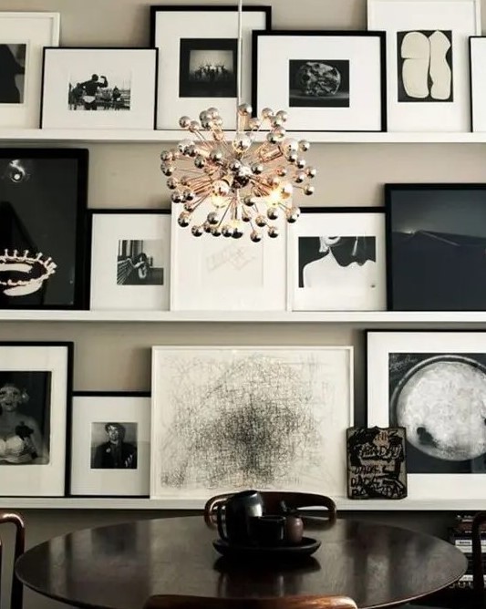 a lovely black and white ledge gallery wall with mismatching frames and matting is a very bold idea to take up a whole wall