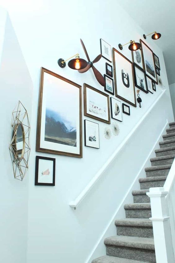 a lovely gallery wall with gorgeous art and photos, mismatching frames, mirrors and chic vintage sconces