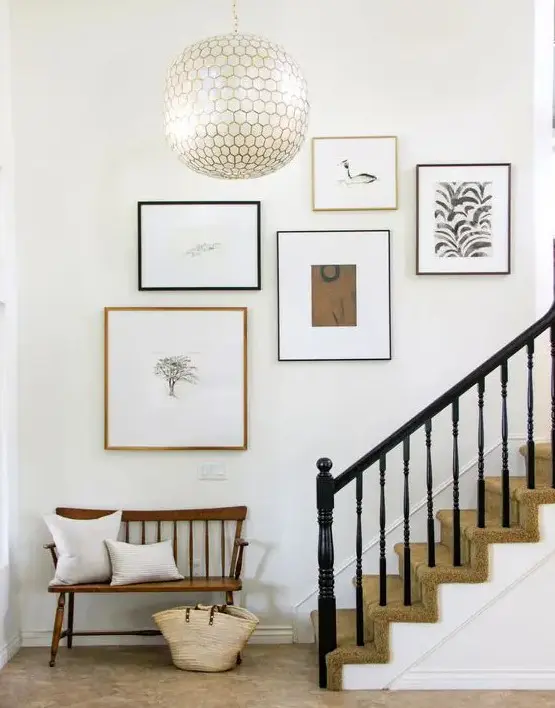 a minimalist staircase gallery wall in black, white and neutrals with mismatching black and neutral frames