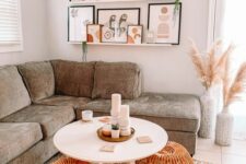 a modern boho living room with a grey sectional, a coffee table, rattan poufs, a ledge gallery wall with catchy artworks