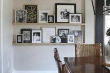 a modern farmhouse space with a stained table and woven chairs, ledges and black and white artwork