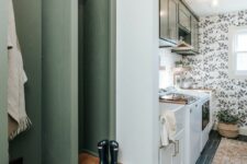 a mudroom laundry with a herringbone tile floor, a green built-in rack and cabinets, a sink and appliances and greenery cabinets