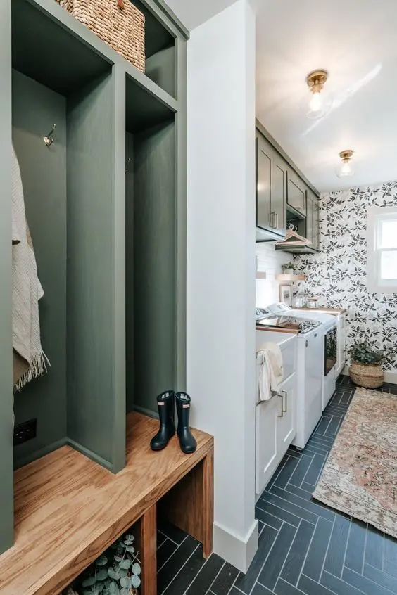 a mudroom laundry with a herringbone tile floor, a green built-in rack and cabinets, a sink and appliances and greenery cabinets
