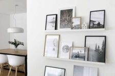 a neutral ledge gallery wall with black and white artwork and bright artwork and botanical pieces is a cool idea