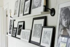 a neutral wall with paneling, ledges and black and white artwork plus sconces is a cool and cozy idea