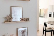 a small and lovely gallery wall with stained ledges, some art, wooden decor and candles is a cool idea