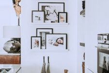 a small gallery wlal with narrow ledges in an awkward kitchen nook, with family photos on black frames is amazing