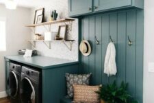 a small yet bright blue mudroom laundry with cabinets, an open storage unit, a washing machine and a dryer and open shelves