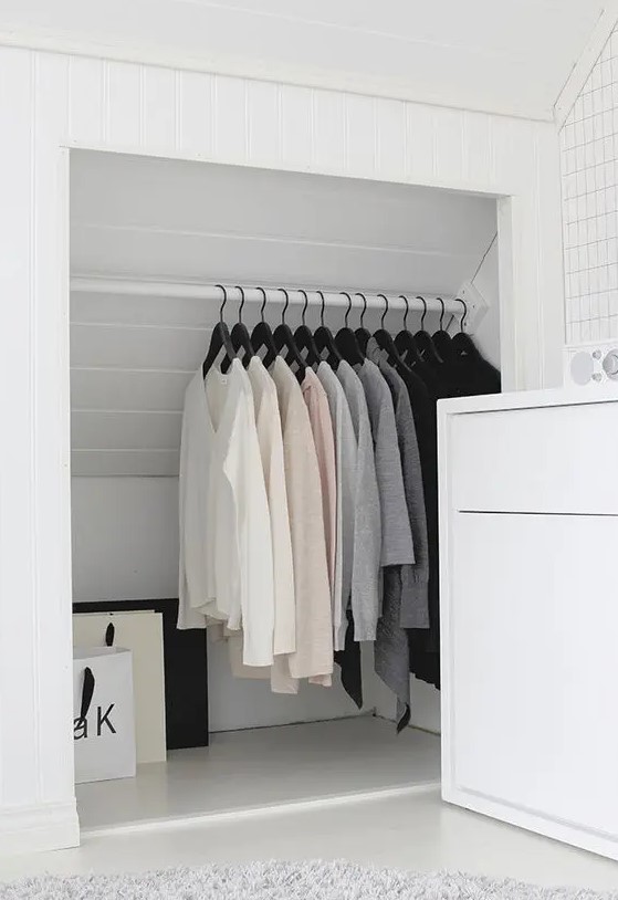 a smart and cool attic storage space turned into a closet with a holder for clothes hangers is a lovely idea