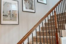 a stylish and laconic gallery wall of wedding photos in matching frames is a cool solution to fill in a blank staircase wall