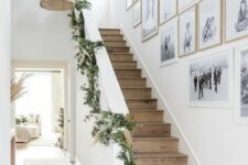 a stylish black and white gallery wall with family pics and artwork in white and stained frames perfectly matches the space
