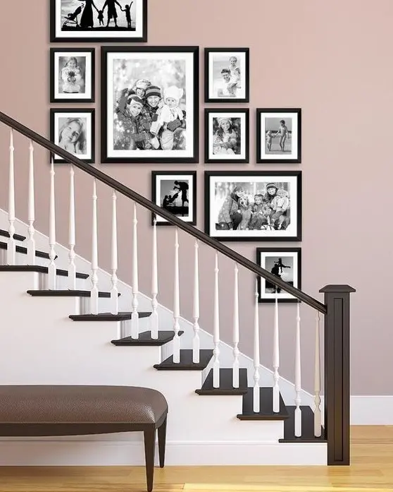 A stylish free form gallery wall with black and white family pics and black frames adds a refined touch to the space