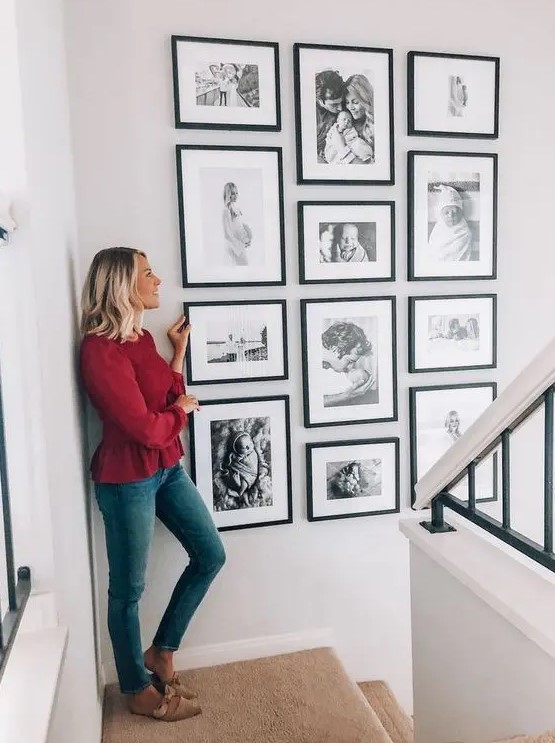 a stylish gallery wall with black and white ffamily pics in matching black frames is amazing and looks perfect