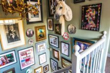 a super bold and fun maximalist gallery wall that takes two walls and includes various art, plates and a unicorn head looks wow