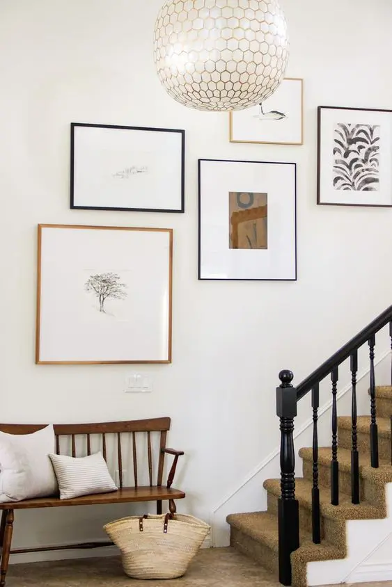 a super chic gallery wall with bold graphic art and other artwork, with mismatching frames looks ethereal and chic