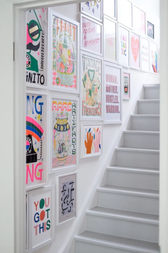 a super colorful staircase gallery wall with bright posters is a cool and fun idea to make your space wow