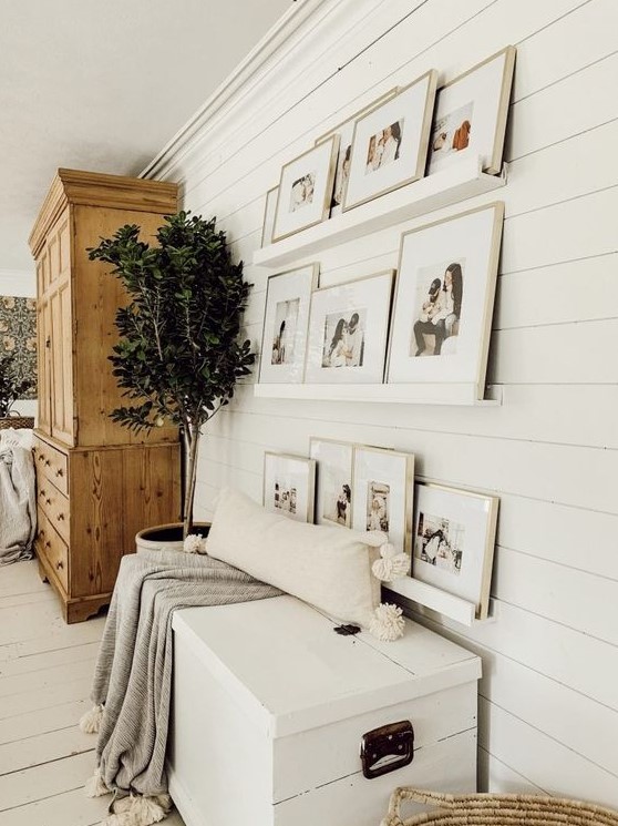 a white wall plus white ledges make the family pics float in the air, all the artworks are framed in neutral tones to merge with the wall even more
