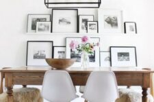 an airy gallery wall with white ledges, black and white artworks in black and white frames perfectly matches a Nordic space