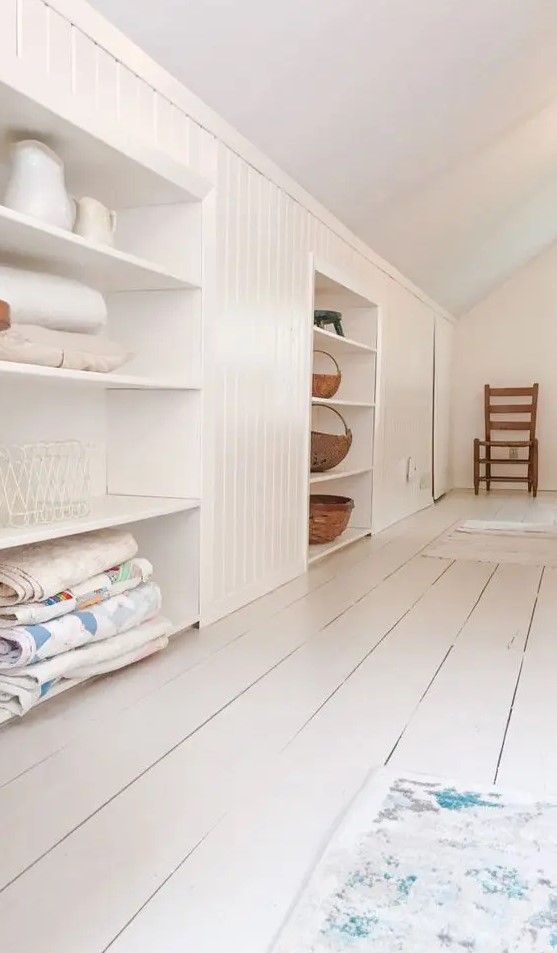 an attic built-in storage space with open shelves and shiplap is a cool idea for a cottage or a farmhouse space in neutrals