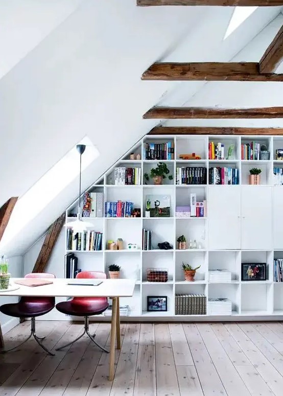 an attic home office with stained wooden beams, a built-in storage unit, a desk, pink and purple chairs and some skylights to give more natural light