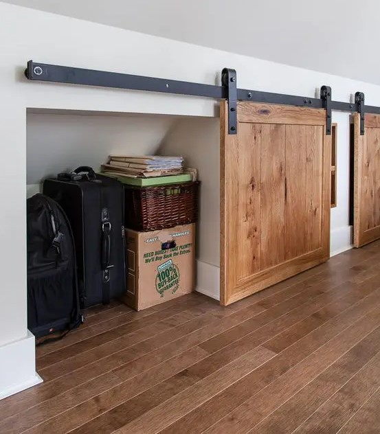 an attic space with built-in storage compartments that are hidden with barn doors is a very smart idea to rock