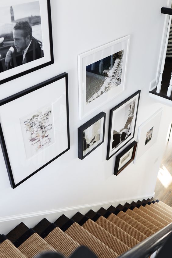 an elegant black and white gallery wall with photos and art plus black and white frames is a gorgeous idea for your space
