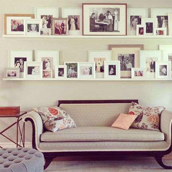 a stylish gallery wall with white ledges and colorful and black and white family pics in white frames is a lovely idea for most of homes